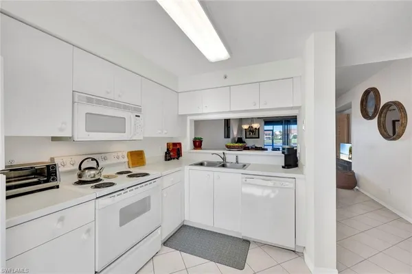 a kitchen with cabinets appliances a sink and a stove top oven