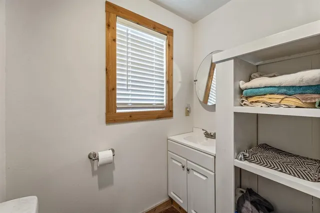 a bathroom with a sink a toilet and a window