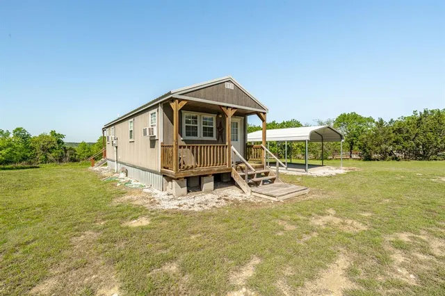 a view of a house with yard and sitting area