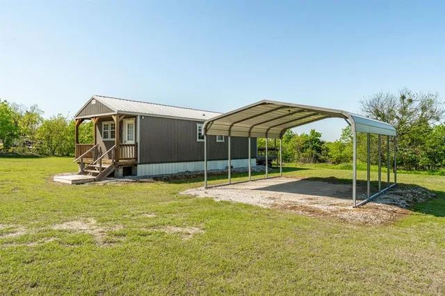 a view of a house with backyard and sitting area