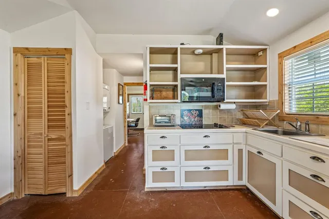 a kitchen with stainless steel appliances cabinets and a window
