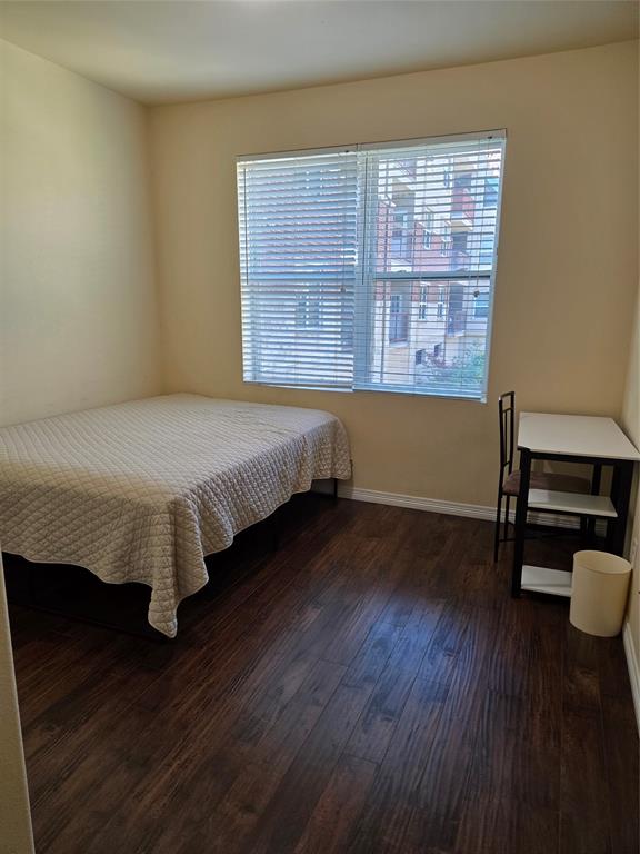 1100 West Trinity Mills Road, Unit 2014 Carrollton, TX 75006 - Photo 11 of 13 a bed sitting in a bedroom next to a window