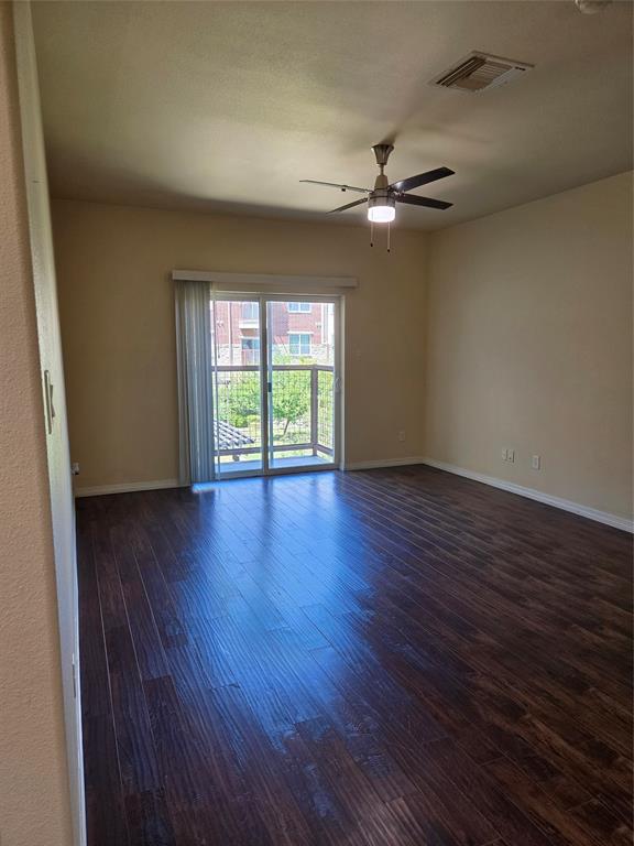 1100 West Trinity Mills Road, Unit 2014 Carrollton, TX 75006 - Photo 2 of 13 a view of an empty room with wooden floor and a window