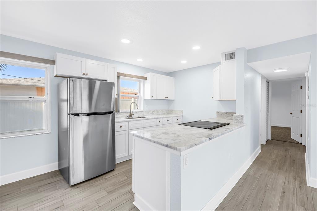 8630 Blind Pass Road, Unit 12 St. Pete Beach, FL 33706 - Photo 11 of 30 a kitchen with a refrigerator a sink and a stove top oven