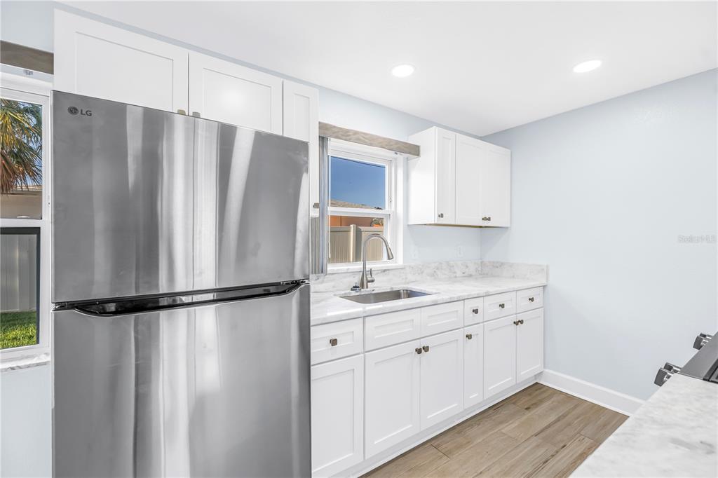 8630 Blind Pass Road, Unit 12 St. Pete Beach, FL 33706 - Photo 12 of 30 a kitchen with stainless steel appliances granite countertop a refrigerator and a sink