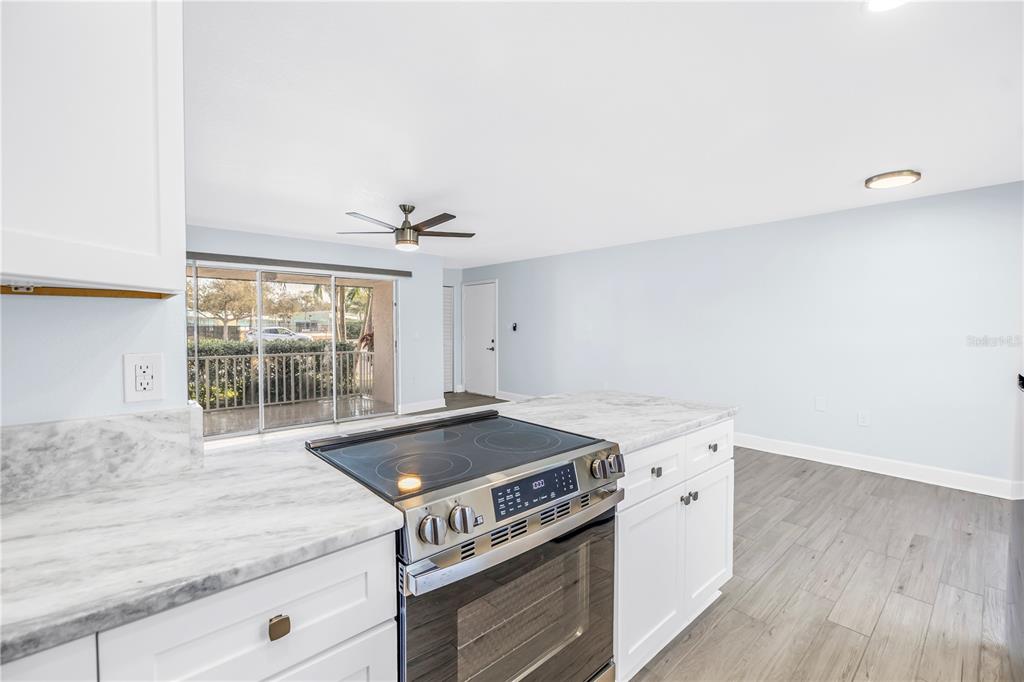 8630 Blind Pass Road, Unit 12 St. Pete Beach, FL 33706 - Photo 13 of 30 a kitchen with a stove and wooden floor