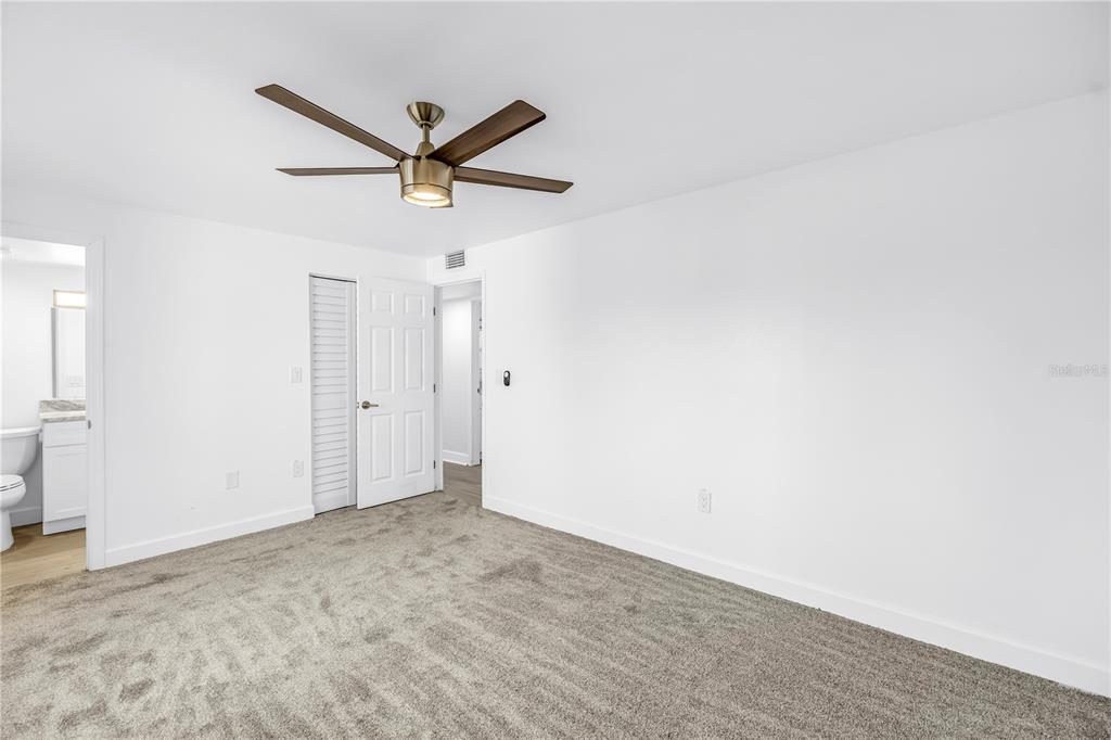 8630 Blind Pass Road, Unit 12 St. Pete Beach, FL 33706 - Photo 17 of 30 a view of a hallway with a ceiling fan