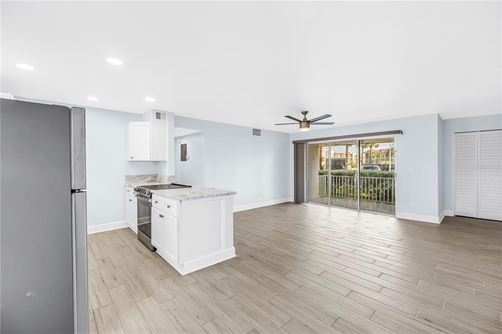 8630 Blind Pass Road, Unit 12 St. Pete Beach, FL 33706 - Photo 7 of 30 a kitchen with stainless steel appliances wooden floors and white walls