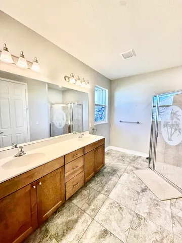 a spacious bathroom with a double vanity sink and a mirror