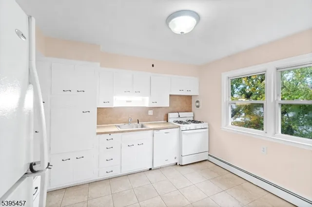 a room with a stove a sink and a window