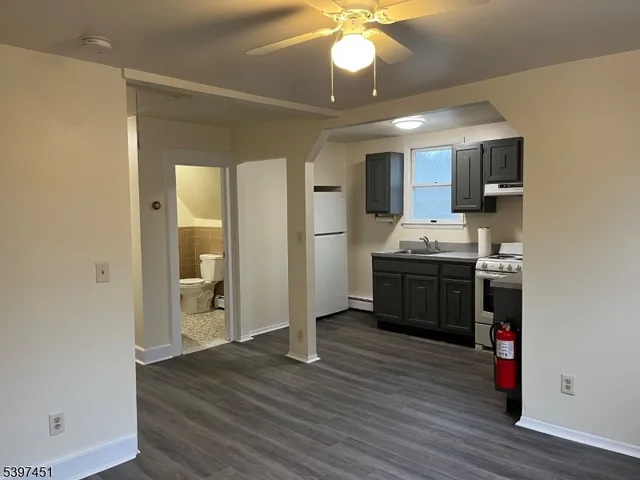a kitchen with stainless steel appliances granite countertop a sink cabinets and wooden floor
