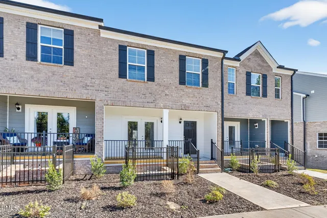 a view of a brick house with large windows and a table