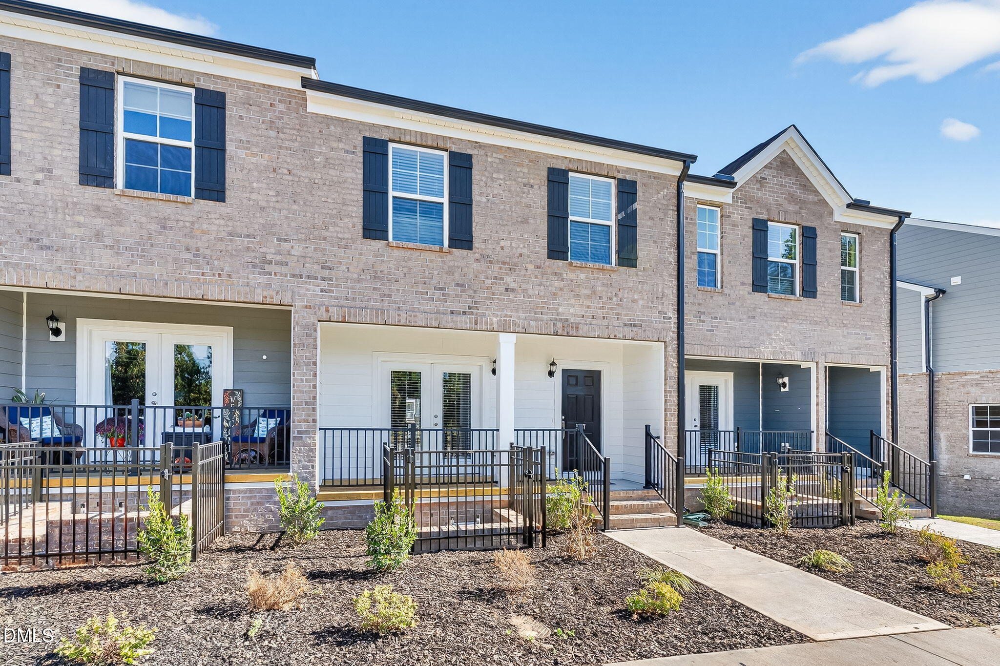 a view of a brick house with large windows and a table