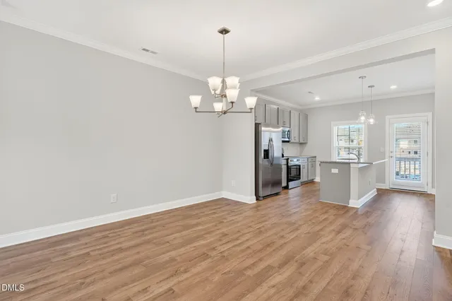 a view of a kitchen with a refrigerator wooden floor and a kitchen
