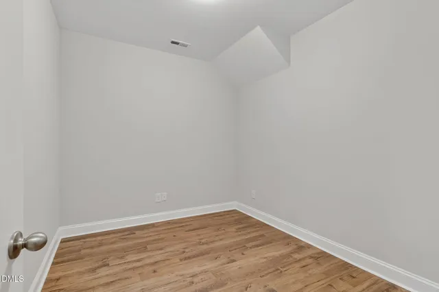 a view of an empty room with wooden floor