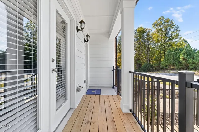 a view of a balcony with wooden floor and fence