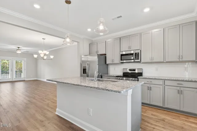 a kitchen with appliances a sink cabinets and wooden floor