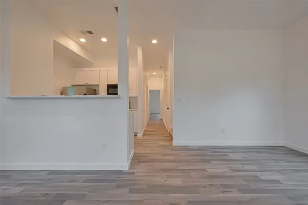 a view of a big room with wooden floor and windows