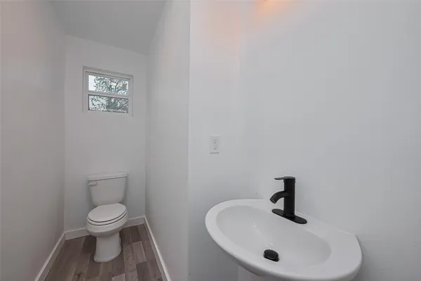 a bathroom with a toilet a sink and mirror