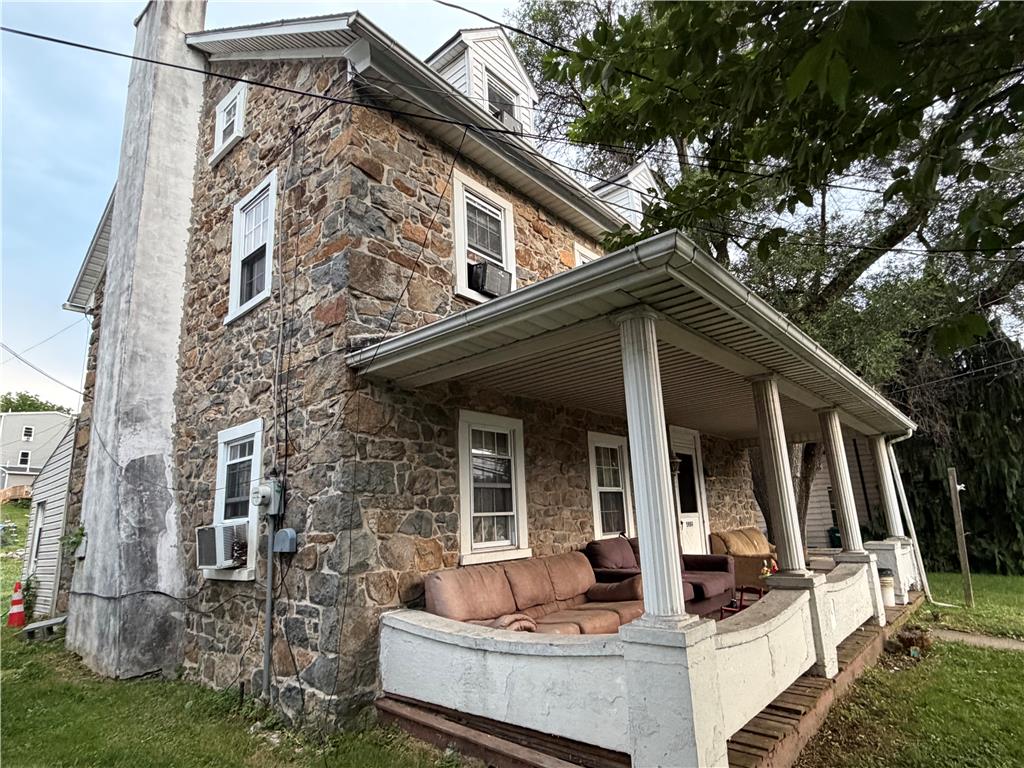 5984 Main Street Center Valley, PA 18034 - Photo 3 of 7 A stone-clad residence boasts a welcoming covered porch, perfect for outdoor relaxation.