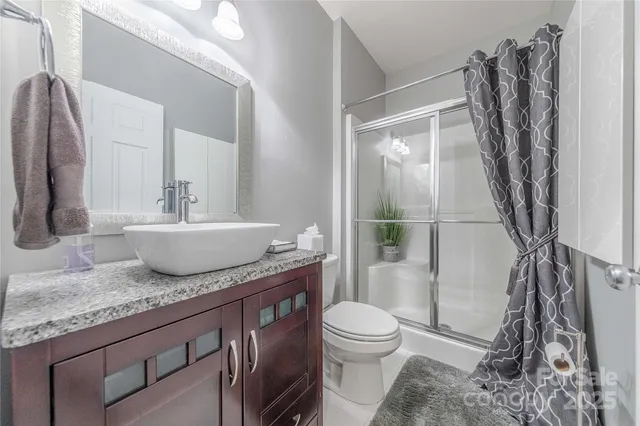 a bathroom with a granite countertop sink toilet and shower