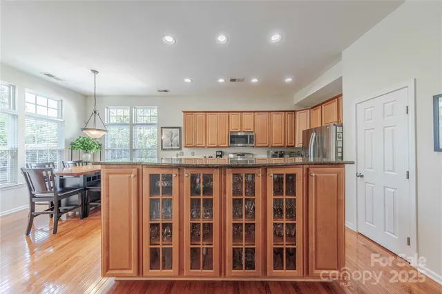 a kitchen with stainless steel appliances kitchen island granite countertop a refrigerator and cabinets