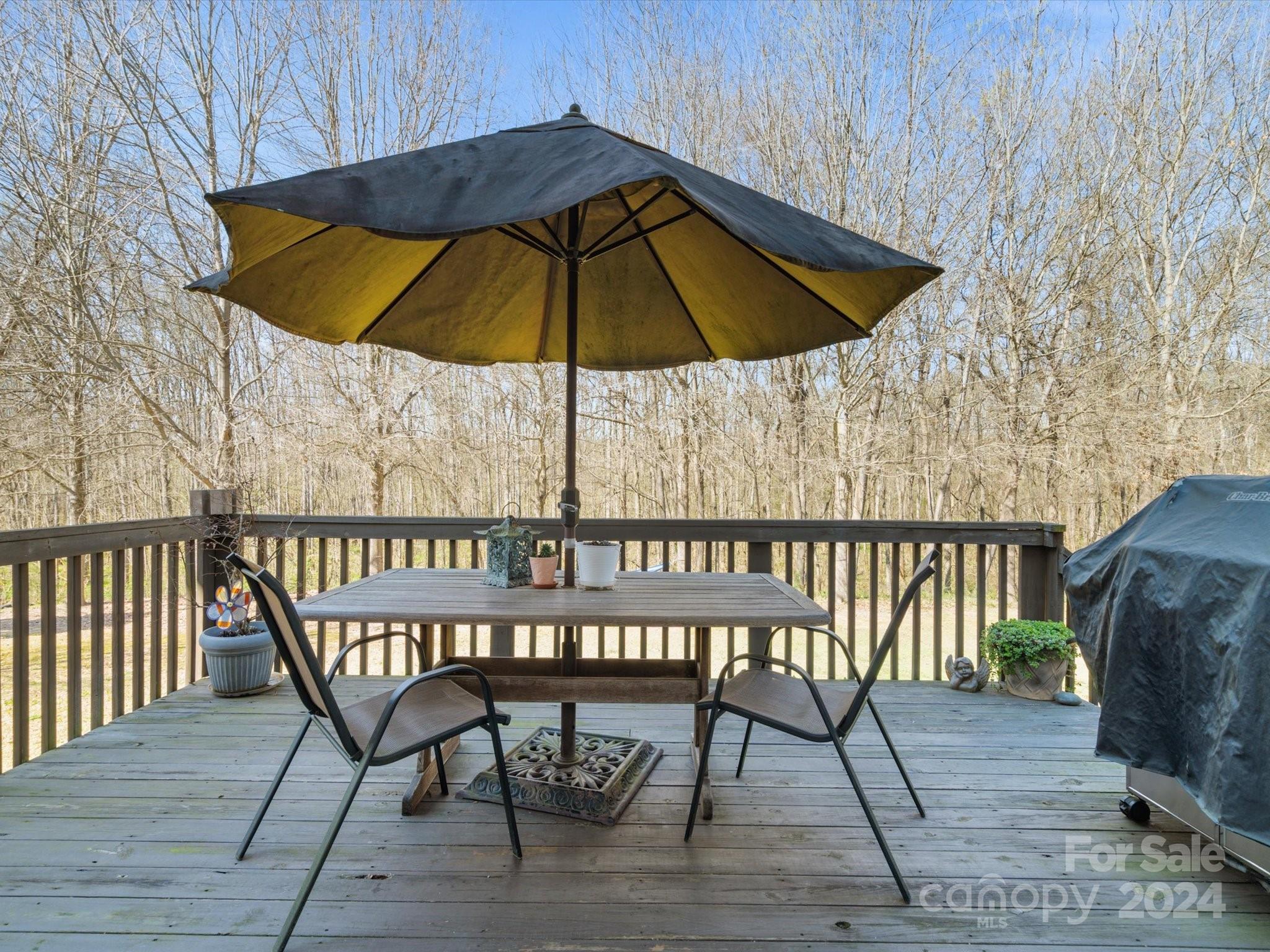 219 Clear Spring Court Fort Mill, SC 29708 - Photo 28 of 38 a wooden deck with a table and chairs under an umbrella