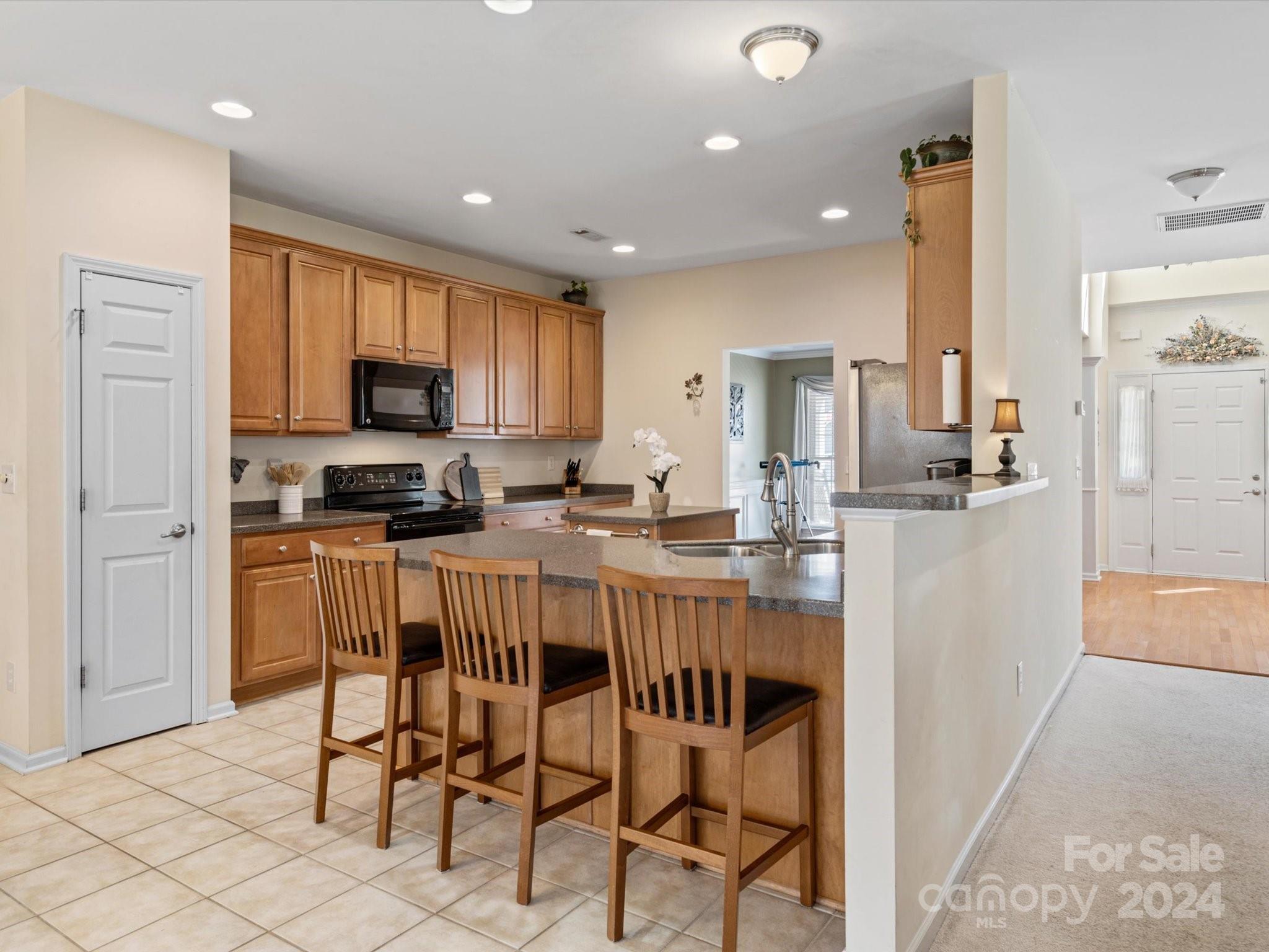 219 Clear Spring Court Fort Mill, SC 29708 - Photo 10 of 38 a kitchen with kitchen island granite countertop wooden cabinets and stainless steel appliances