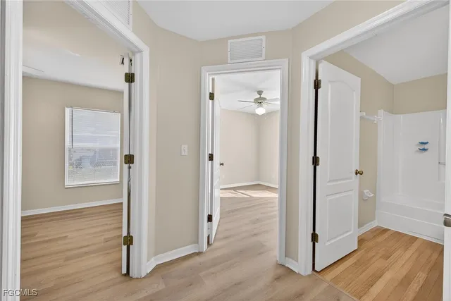 a view of a bathroom with tub mirror and window