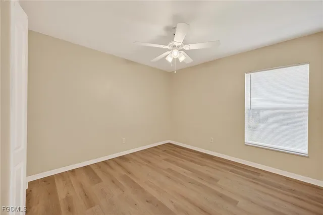 an empty room with a window and wooden floor