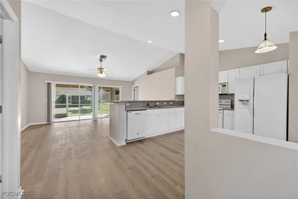 a view of kitchen with wooden floor and electronic appliances