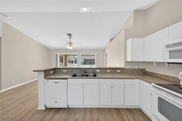 a kitchen with granite countertop a sink and cabinets