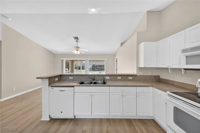 a kitchen with granite countertop a sink and cabinets