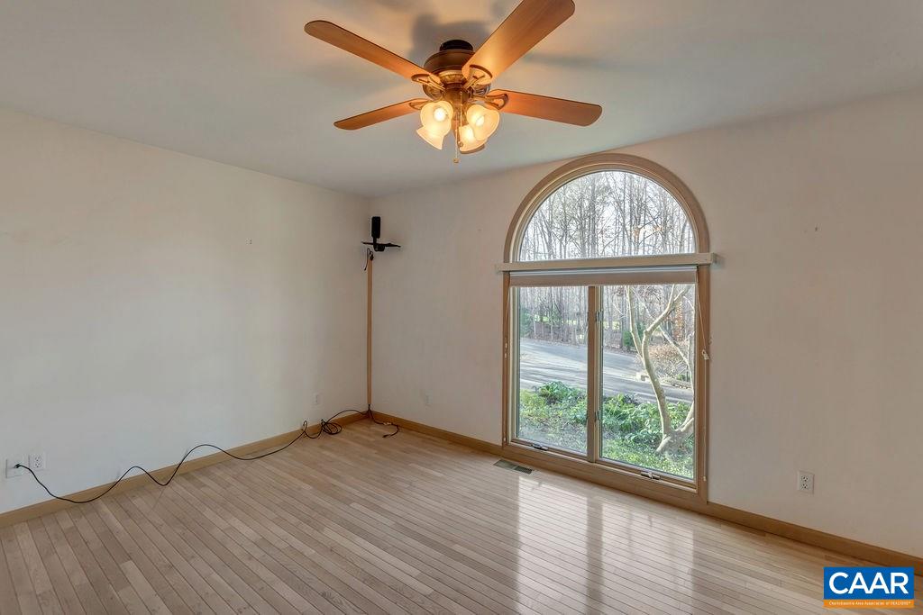 9 Out Of Bounds Road Palmyra, VA 22963 - Photo 23 of 37 an empty room with wooden floor fan and a window
