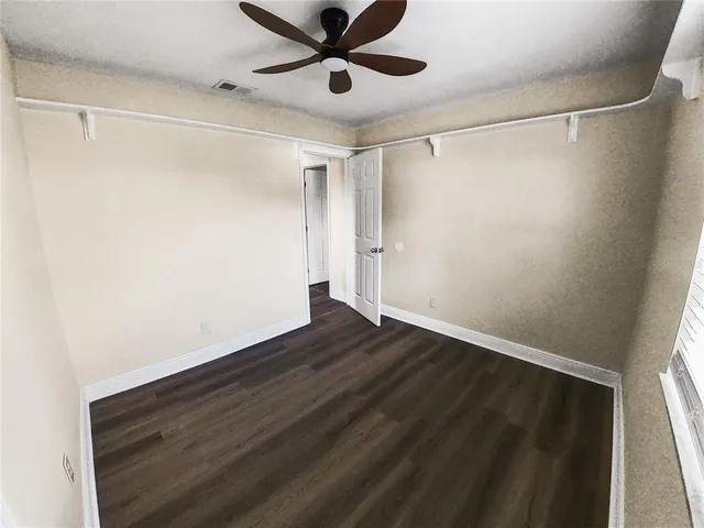 a view of an empty room with wooden floor