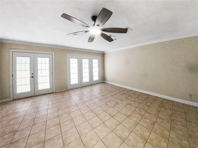 an empty room with windows and fan