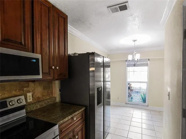 a kitchen with stainless steel appliances granite countertop a refrigerator and a stove top oven