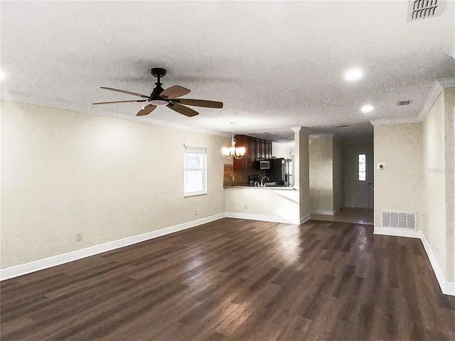 a view of empty room with wooden floor and window