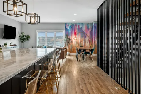 a dining room with furniture a chandelier and wooden floor
