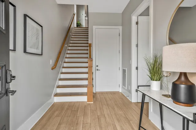 a view of a hallway with wooden floor and stairs