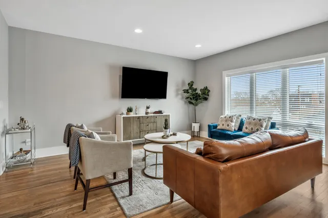 a living room with furniture a flat screen tv and a large window