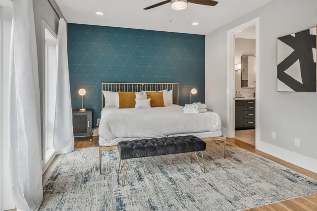 a bedroom with a large bed and a wooden floor