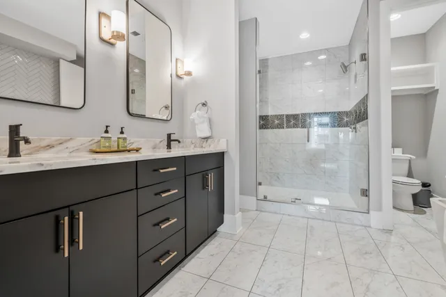 a bathroom with a double vanity sink mirror and shower