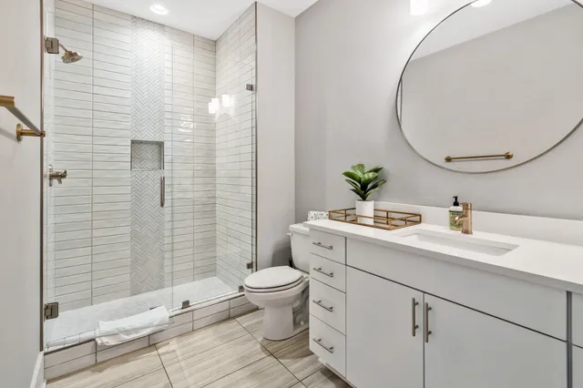 a bathroom with a sink a toilet and shower