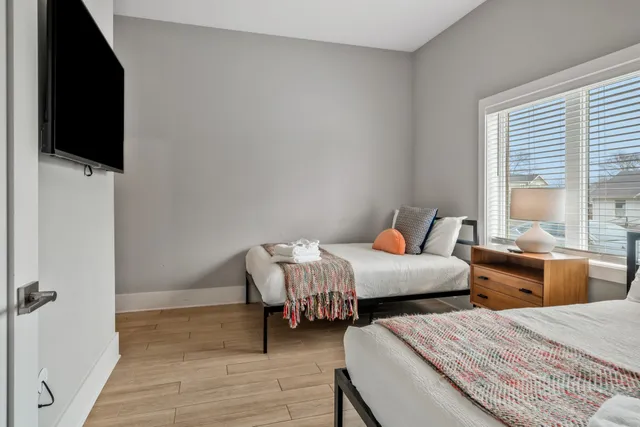 a bedroom with two beds and a flat screen tv