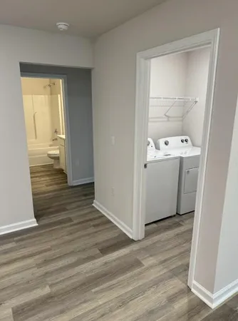 a view of utility room with wooden floor washer and dryer