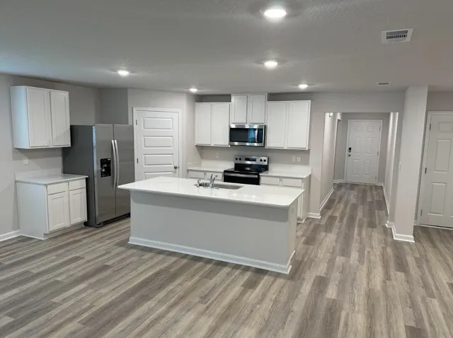 a view of kitchen with microwave a stove and a refrigerator