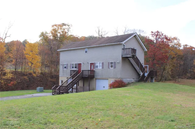 a view of a house with a yard and sitting area