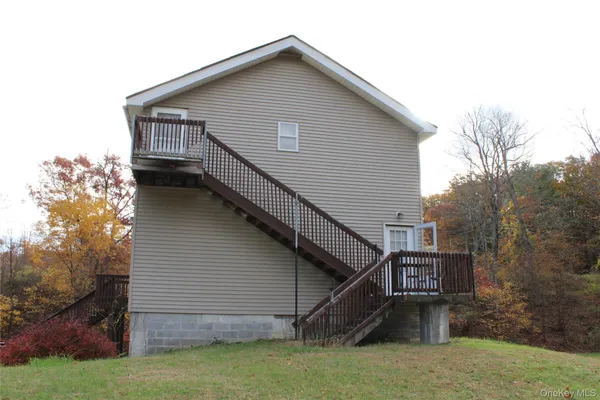 a view of house with backyard and trees