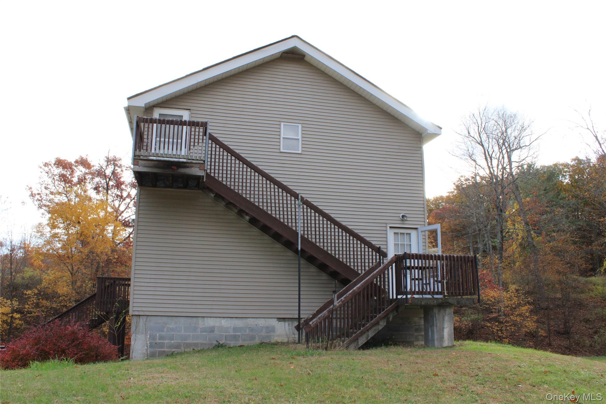 400 Round Lake Road Rhinebeck, NY 12572 - Photo 13 of 34 View of home's exterior with stairway, a wooden deck, and a lawn